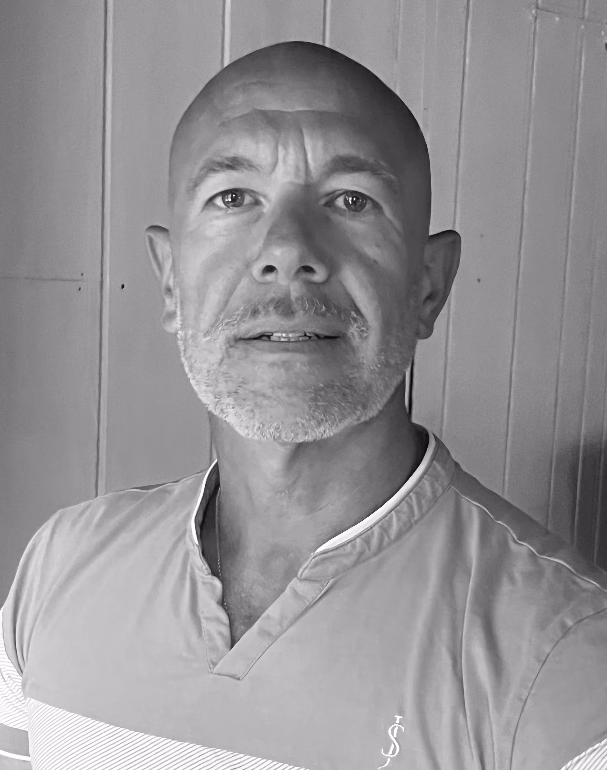 A black and white portrait photograph of Darren Jones