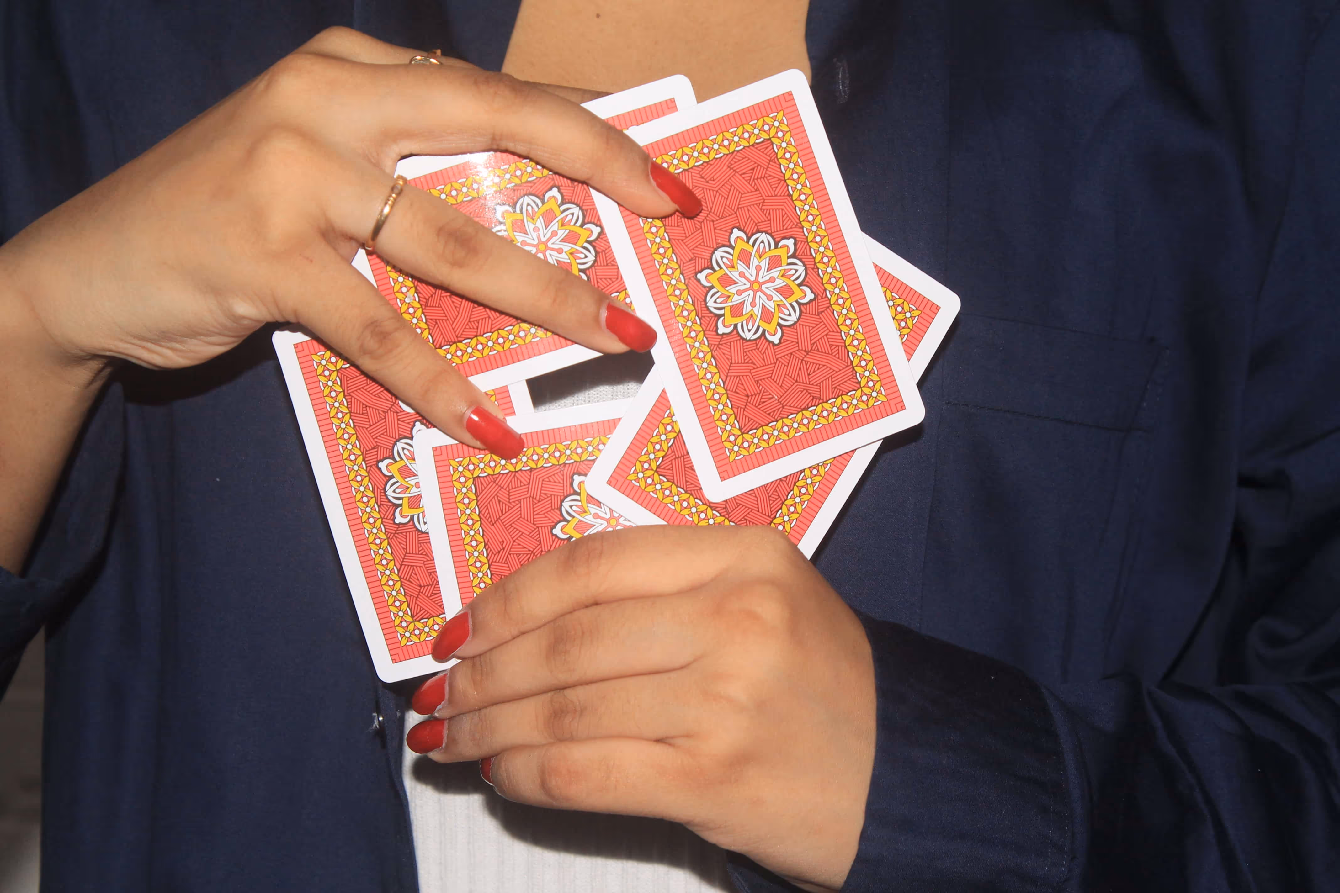Wiski Brandi playing cards fanned in a circular shape and held in hand, showing the vibrant backs and clean vintage design under soft light.