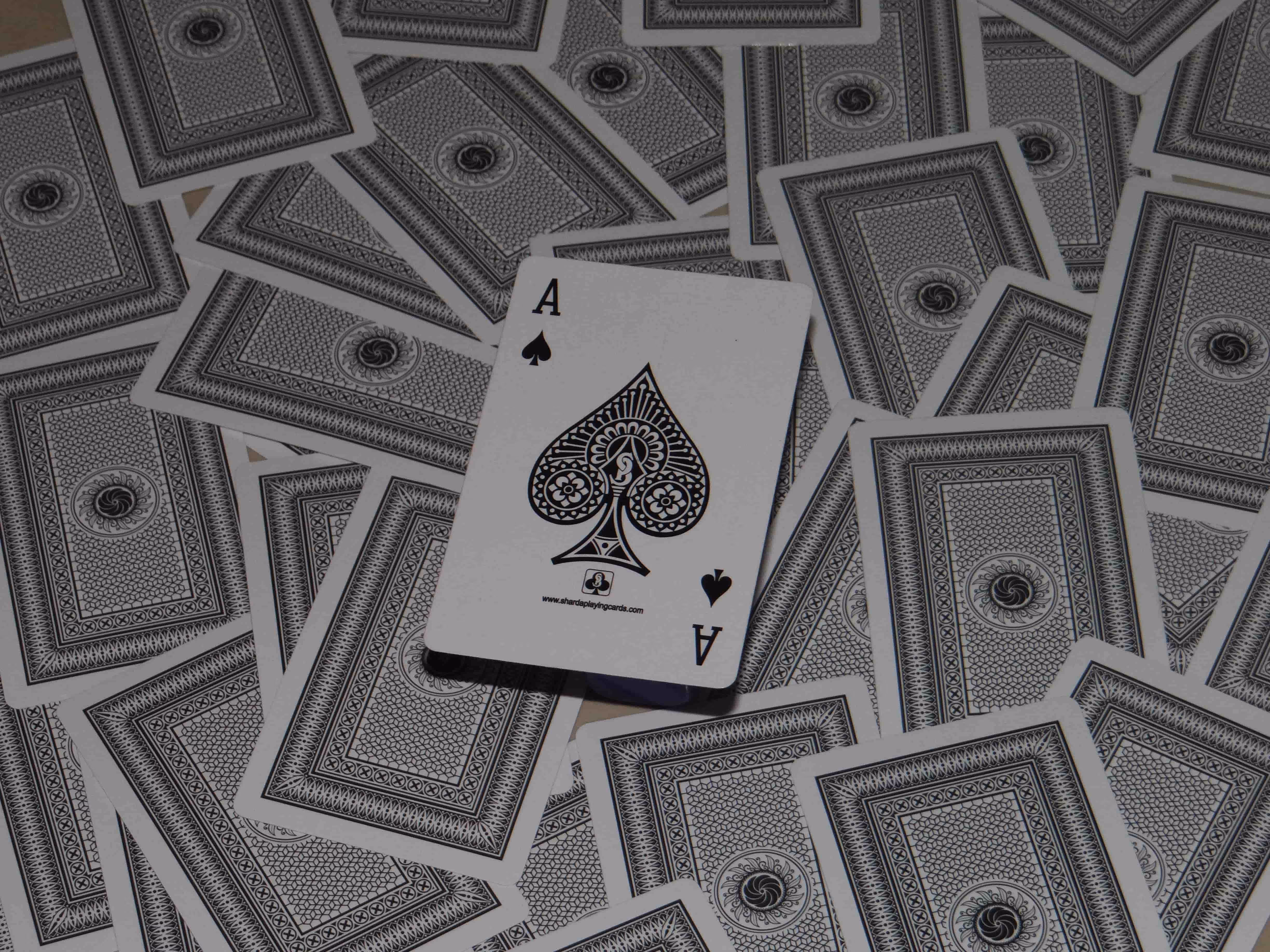 Hi-Tech Gold cards arranged on the floor with the back design visible beneath and the Ace of Spades placed neatly on top, capturing precision, luxury, and balance