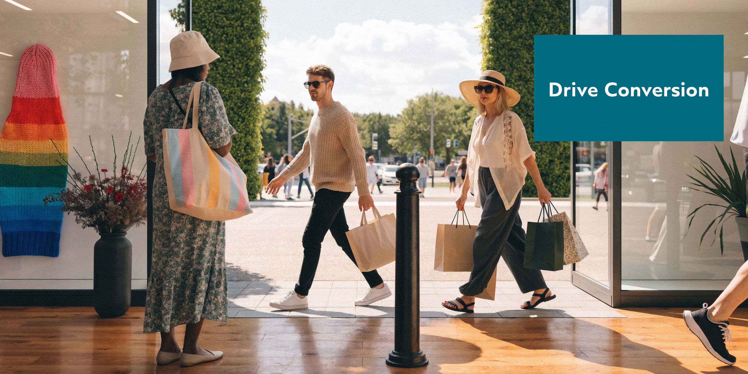 Diverse shoppers entering a modern retail store with shopping bags on a sunny day in the city.