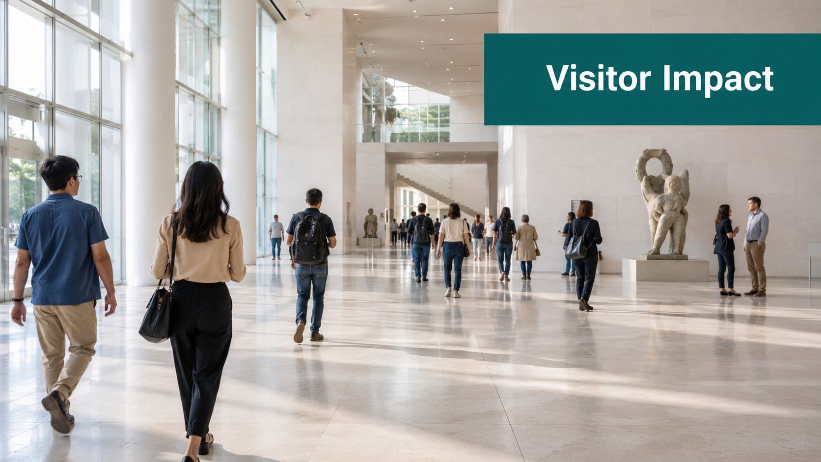 A wide, bright museum hall with visitors walking towards sculptures in a spacious, modern architectural setting.