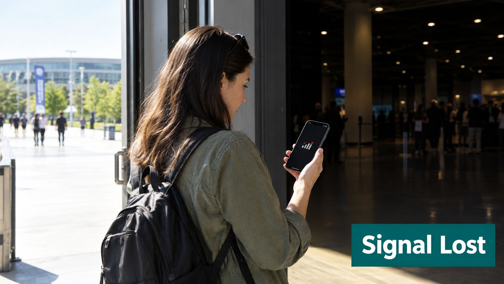 A woman stands in a doorway holding a smartphone displaying a no signal icon on the screen.