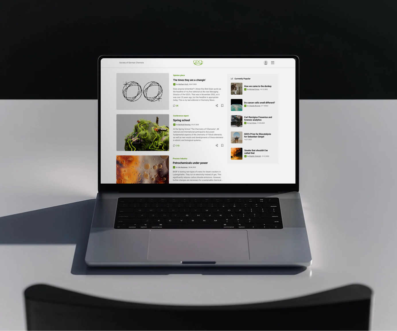 Laptop displaying the GDCh website in dark mode with a digital library of scientific journal covers.