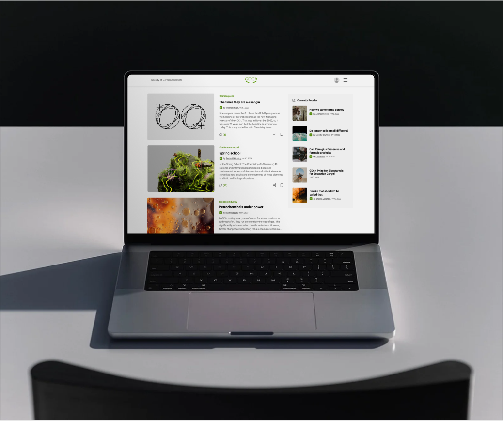 Laptop displaying the GDCh website in dark mode with a digital library of scientific journal covers.