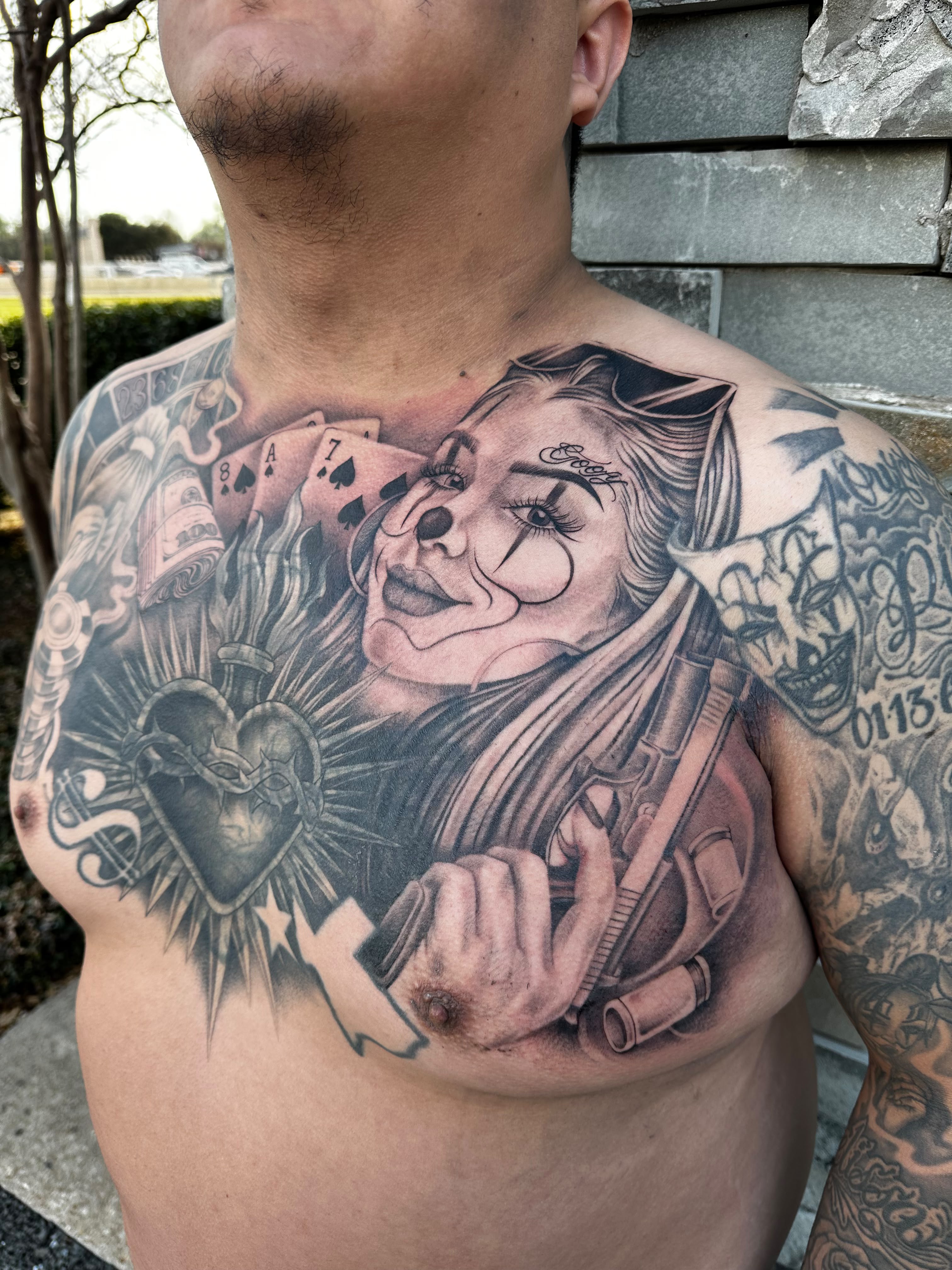 Chicano-style clown girl chest tattoo detail in black and grey by Dani B, Fort Worth