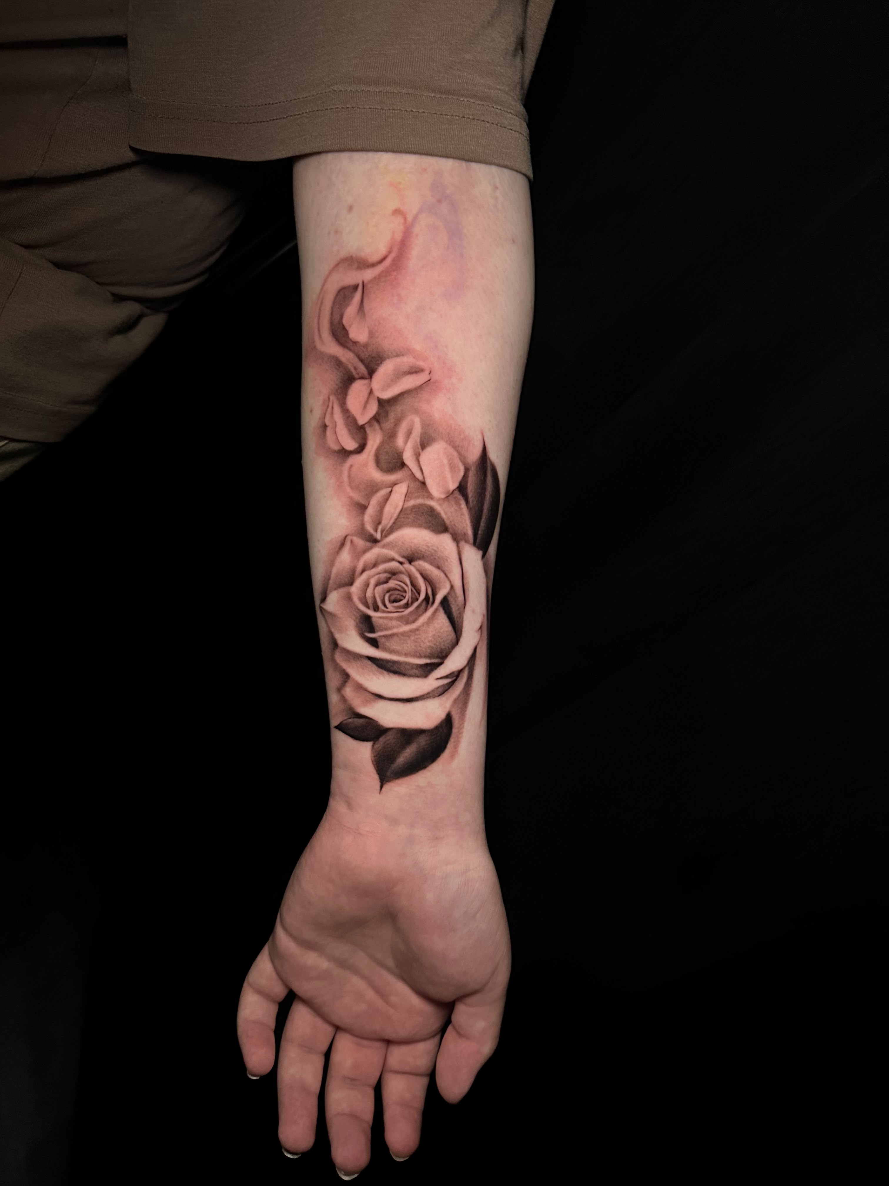 Realistic black and grey rose with floating petals forearm tattoo by Dani B, Fort Worth