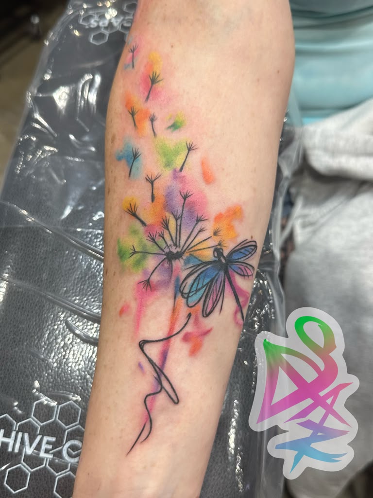 Watercolor dandelion and dragonfly tattoo in rainbow colors by Jasmyn SweetJaz