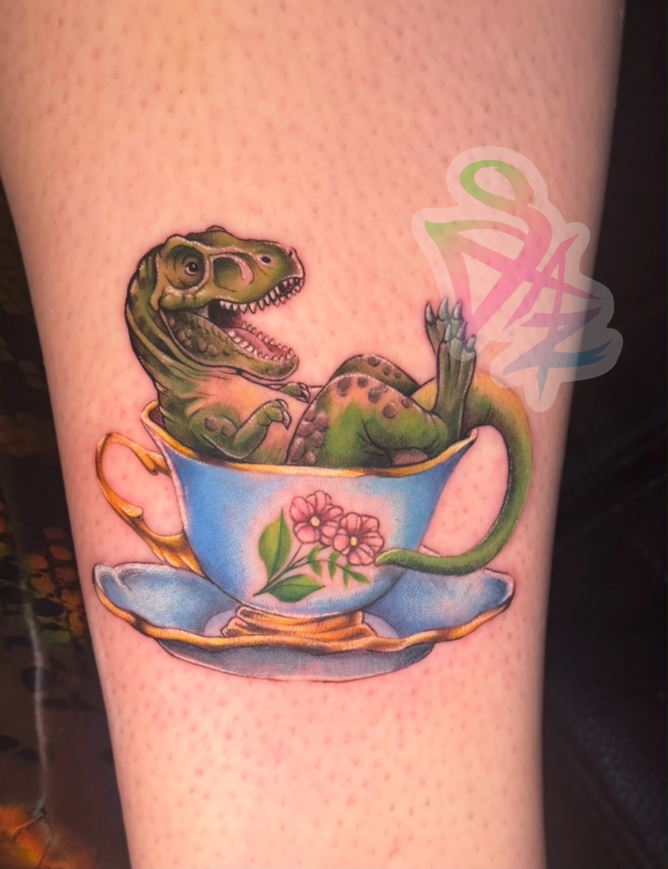 Color tattoo of a T-rex in a floral teacup by Jasmyn SweetJaz, Fort Worth tattoo artist