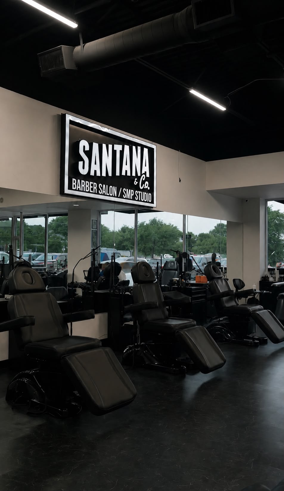 Barber chairs beneath the Santana & Co Barber Salon sign at the Fort Worth studio
