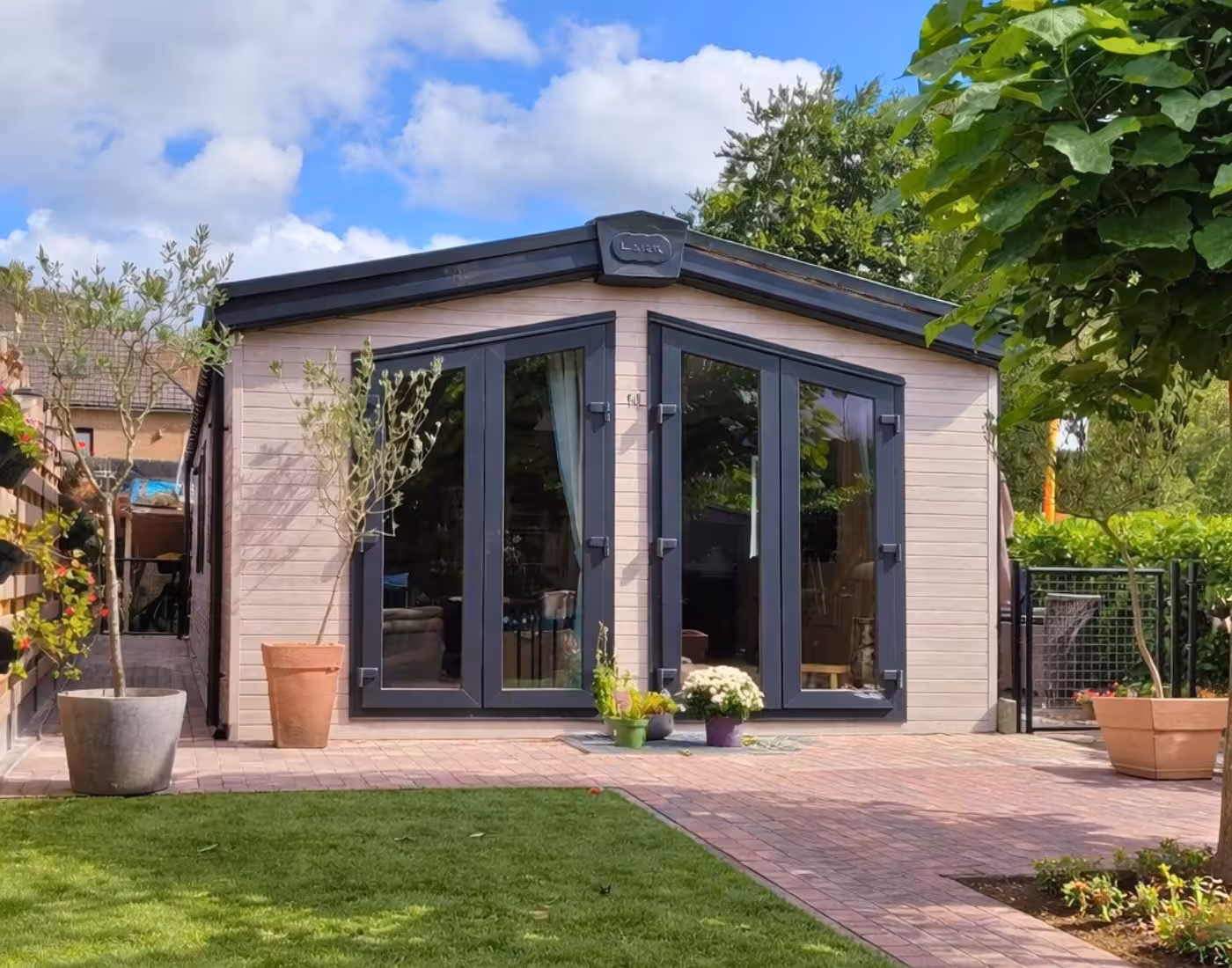 Murano-zorgwoning in een tuin, met glazen hoekgevel en een pad naar de voordeur