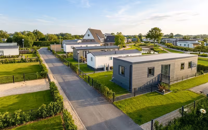 Overzicht van een camping met stacaravans, groene staanplaatsen en toegangswegen