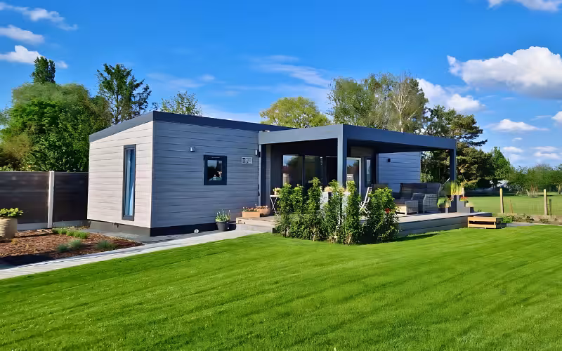 Moderne woning met houten gevel en overdekt terras in een groene tuin
