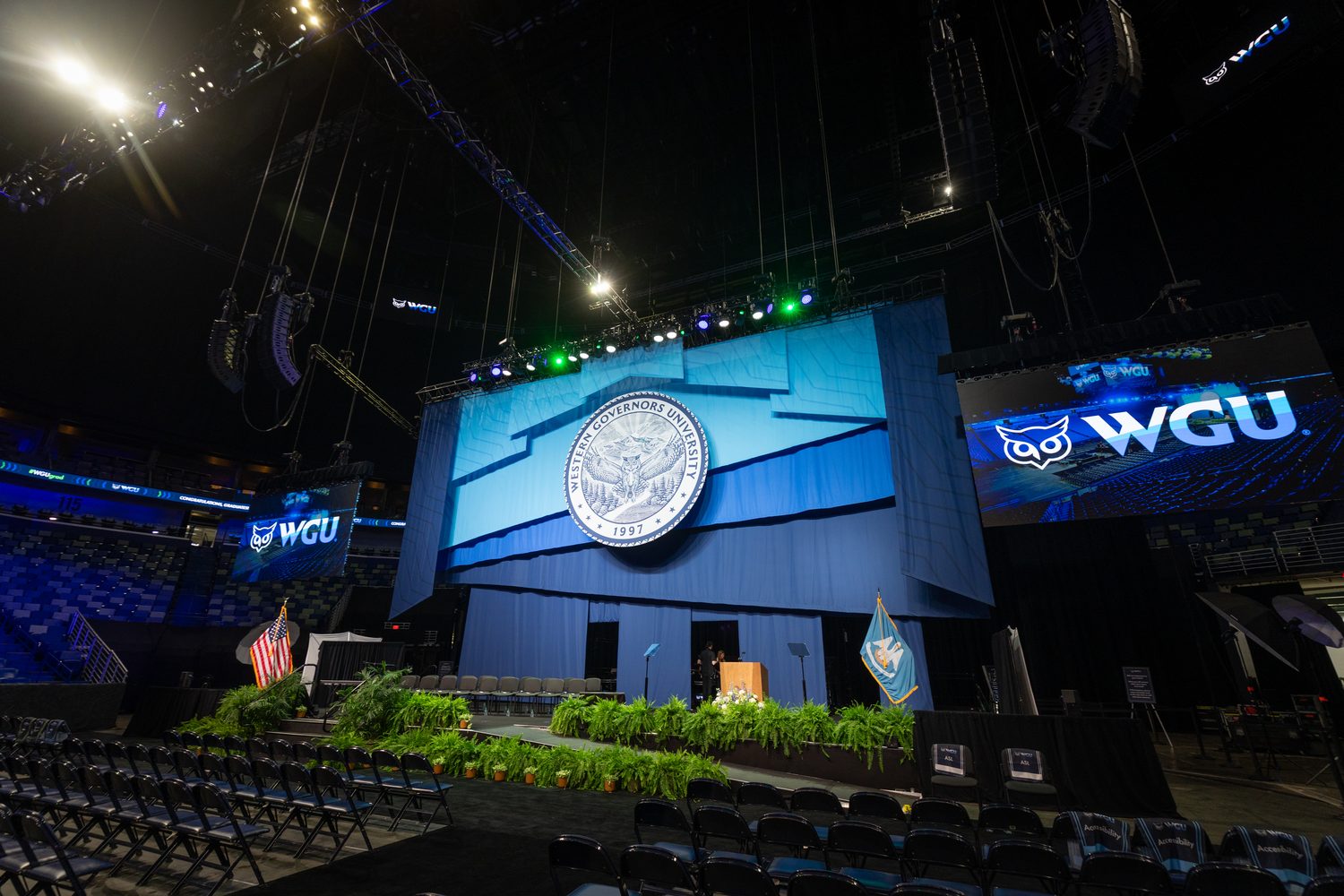 WGU commencement stage with the university seal in a full arena