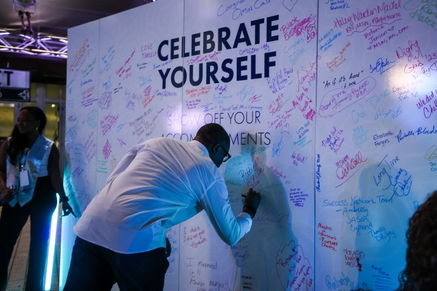 Graduate signing the WGU Celebrate Yourself wall