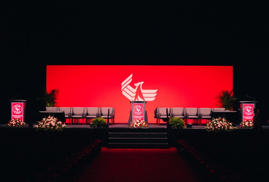 University of Phoenix commencement stage set with phoenix backdrop