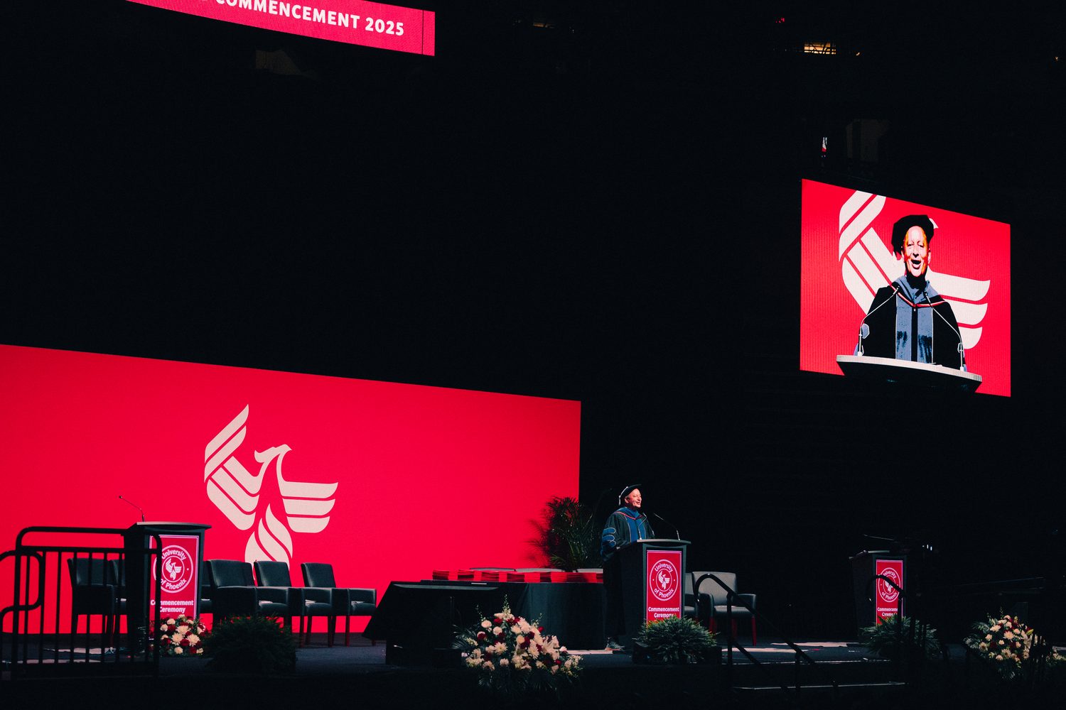 University of Phoenix commencement stage with speaker and phoenix branding