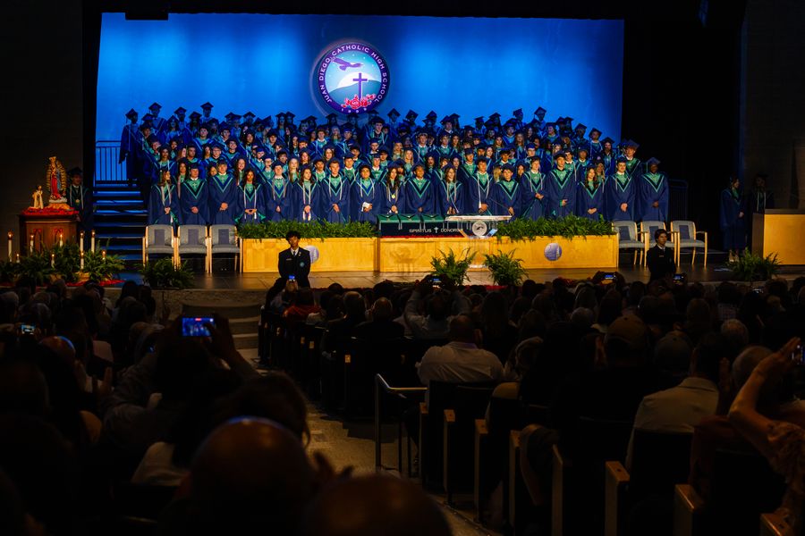 Juan Diego graduating class on stage in cap and gown