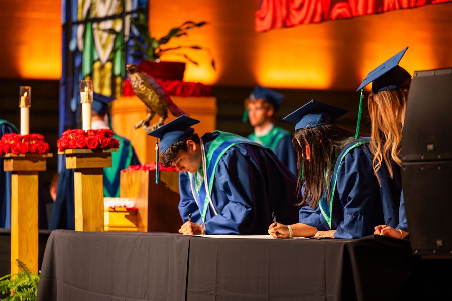 Juan Diego graduates signing at the ceremony