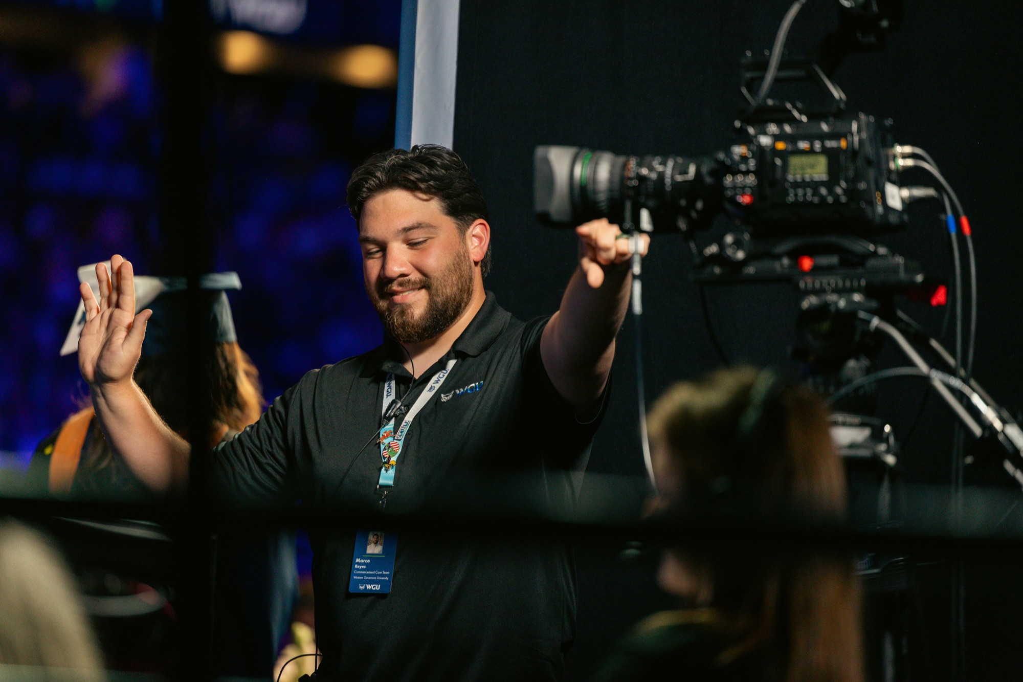 Camera operator celebrating with graduates at the stage exit