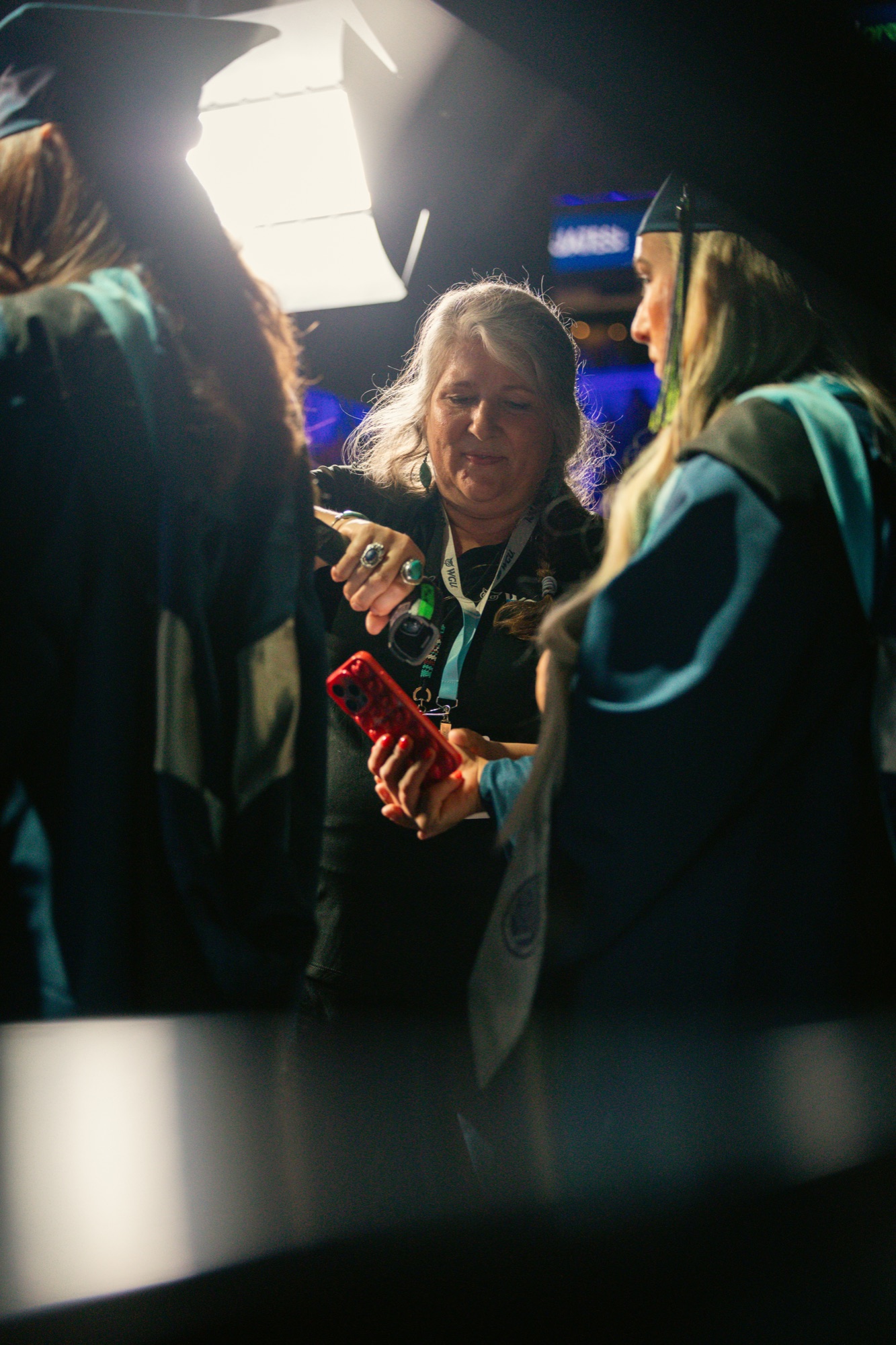 Staff scanning a graduate's phone at check-in