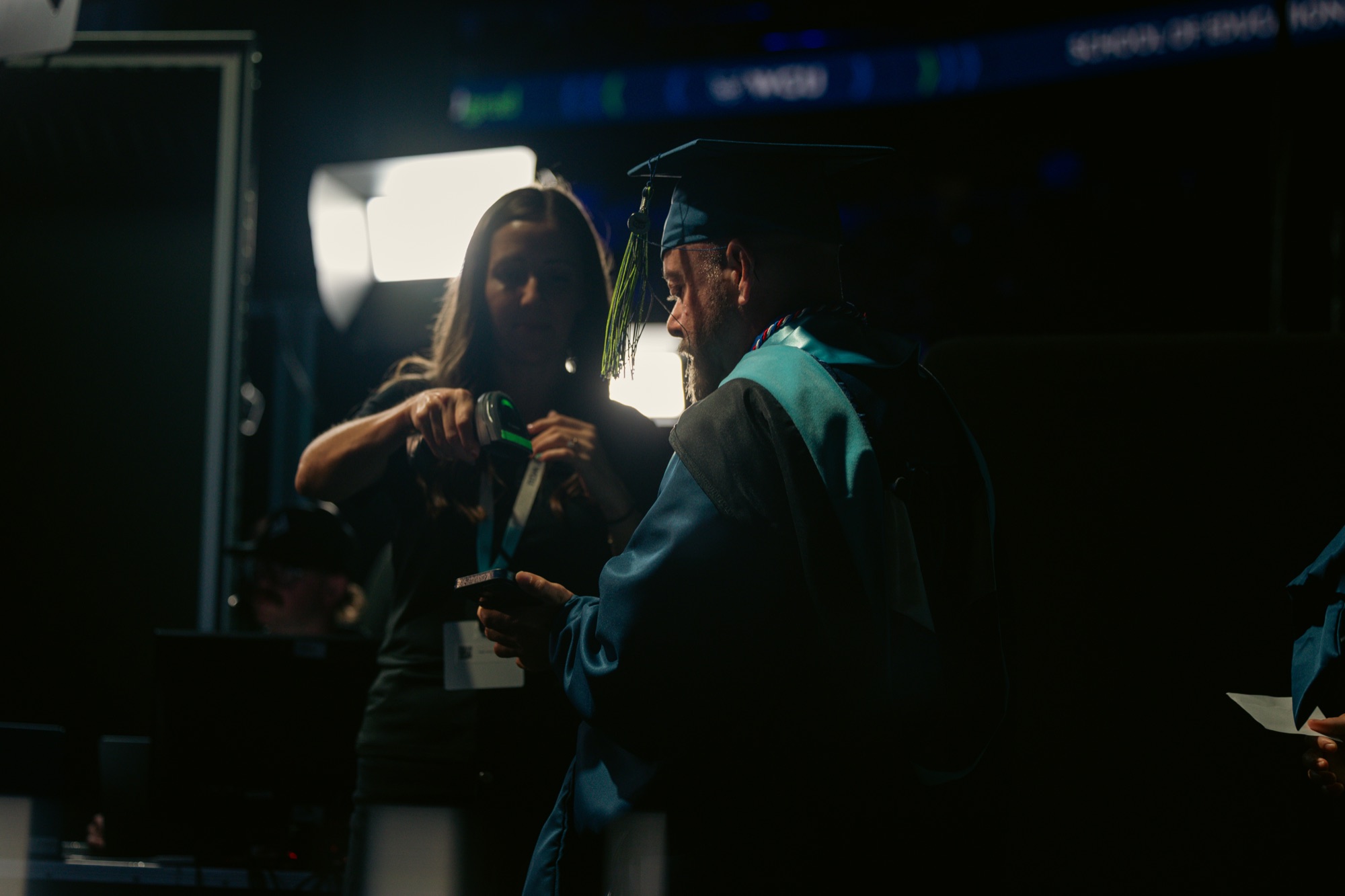 Close-up of a graduate's credential being scanned backstage