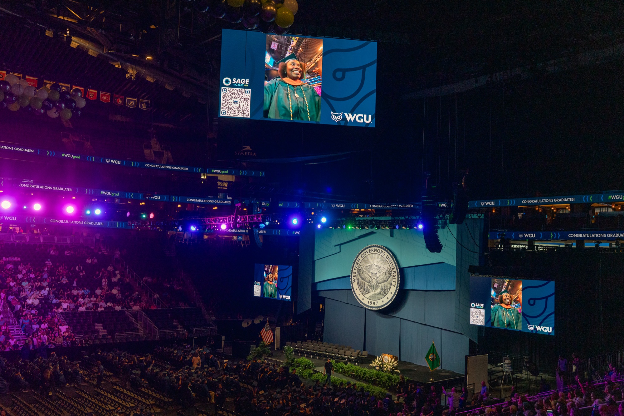 Graduate close-up with QR code on the arena jumbotron