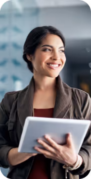 Mujer sonriente sosteniendo una tableta digital en un entorno de oficina moderno.