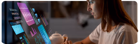 Mujer usando una computadora portátil con gráficos y datos digitales flotando en la pantalla.