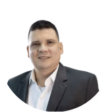 Hombre sonriendo con traje gris y camisa blanca, fondo transparente.