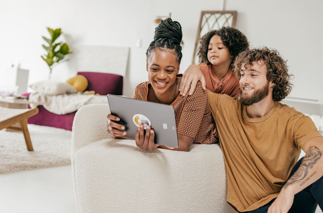 Family smiling looking at computer