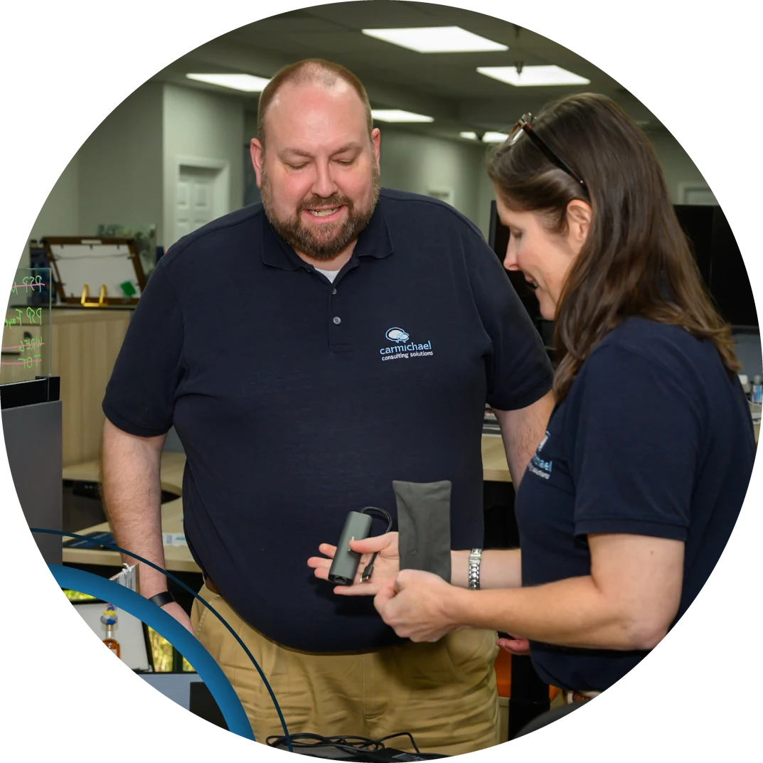 Carmichael team members reviewing a device together in the office