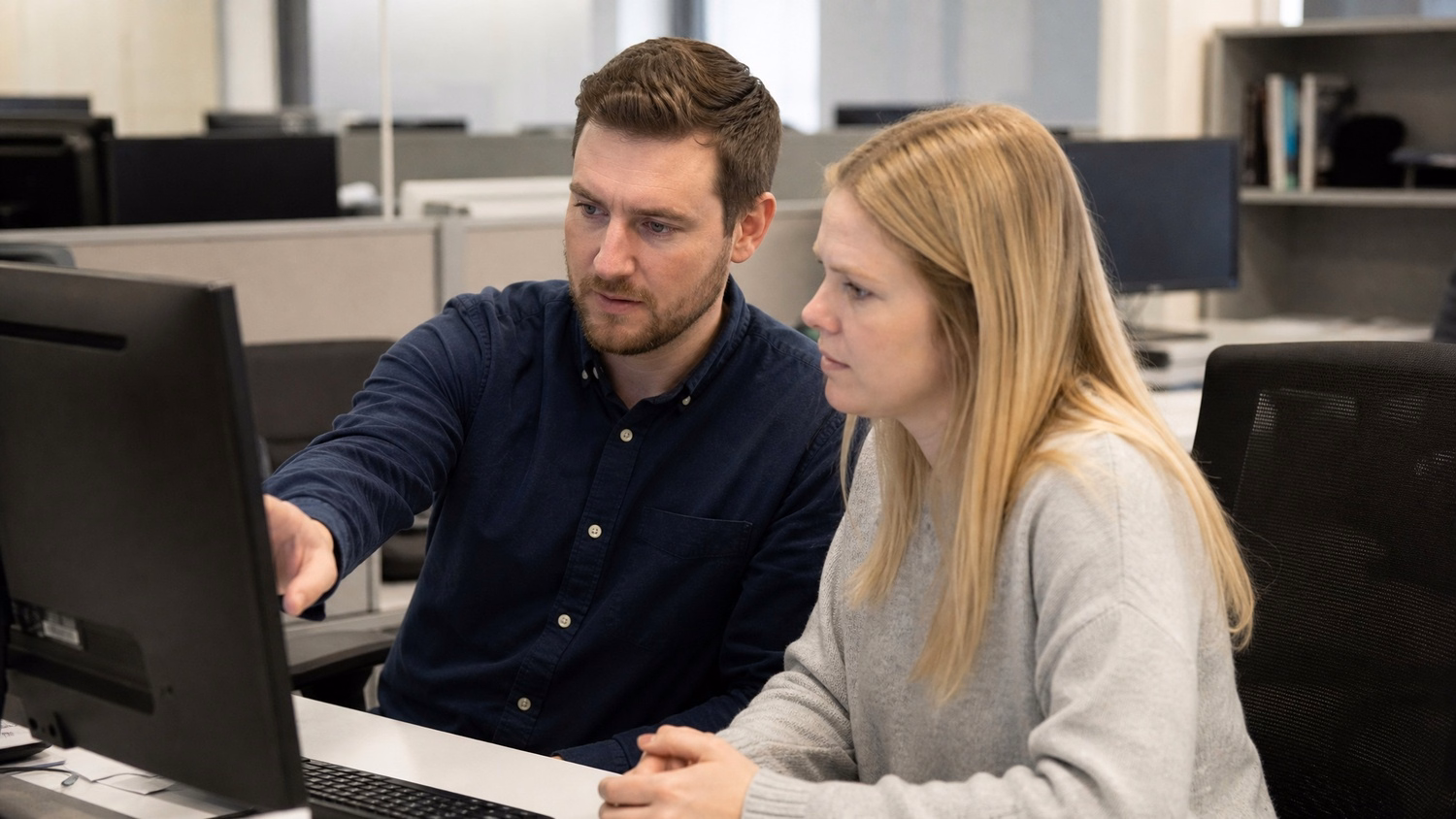 SIDE-BY-SIDE PAIR, two people seated side by side reviewing something on a