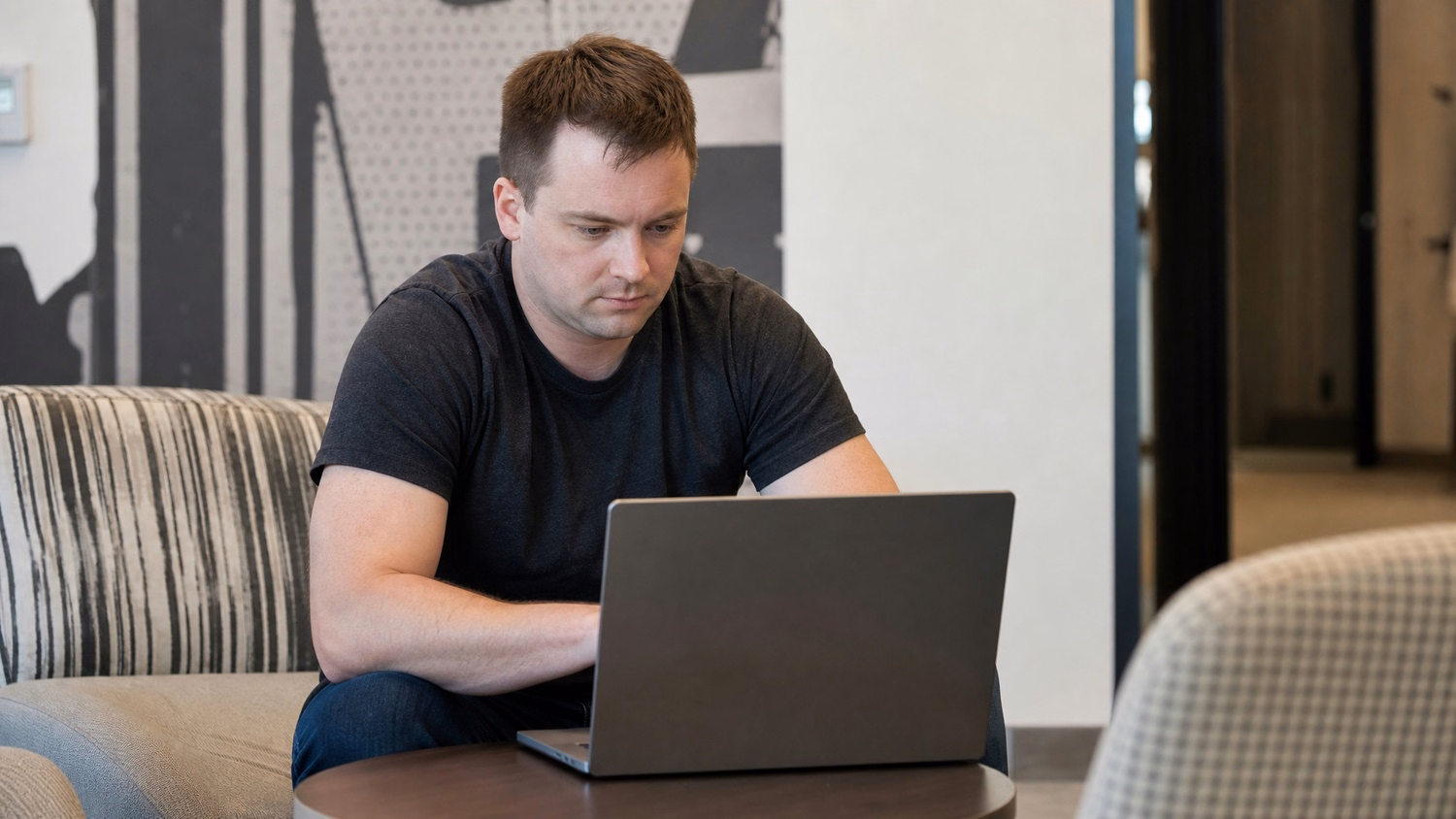 LOUNGE AREA LAPTOP An IT professional one person working on a laptop in a ca