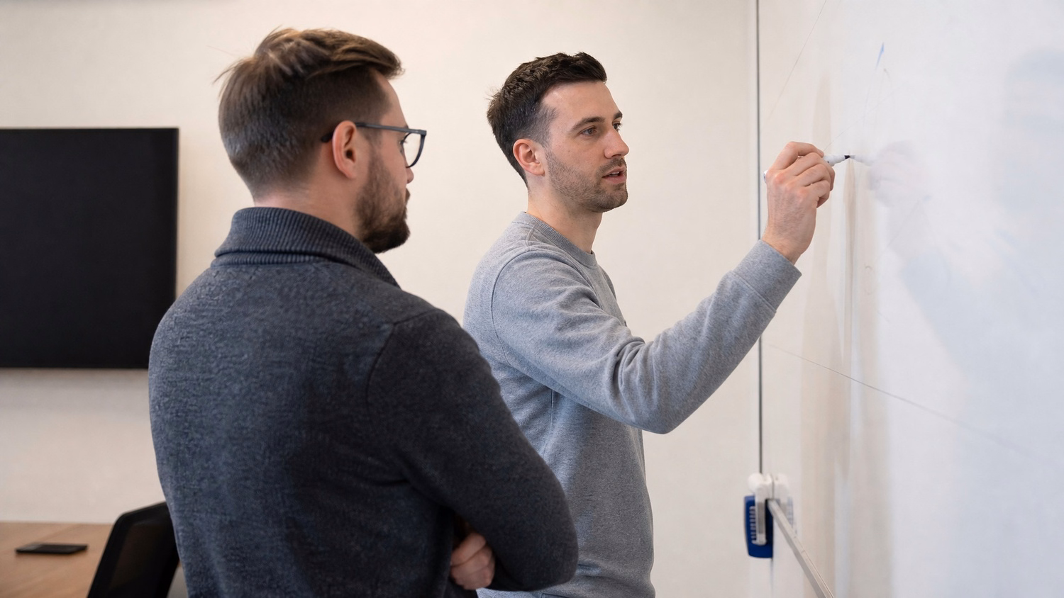 WHITEBOARD SESSION An IT professional  one or two people standing at a whiteb