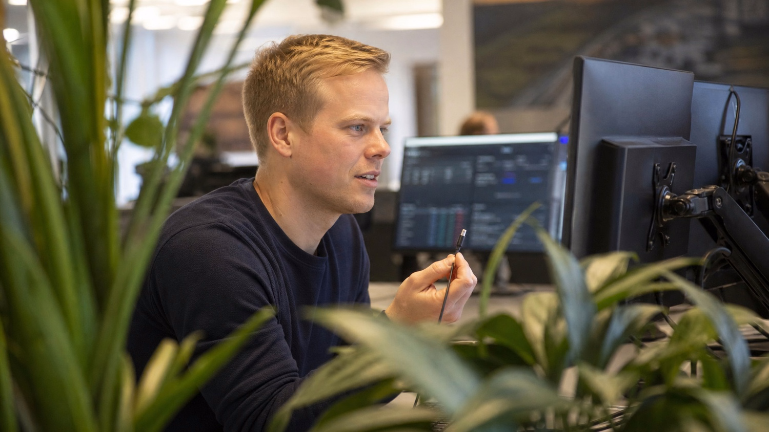 Desk technician troubleshooting hardware near office plants