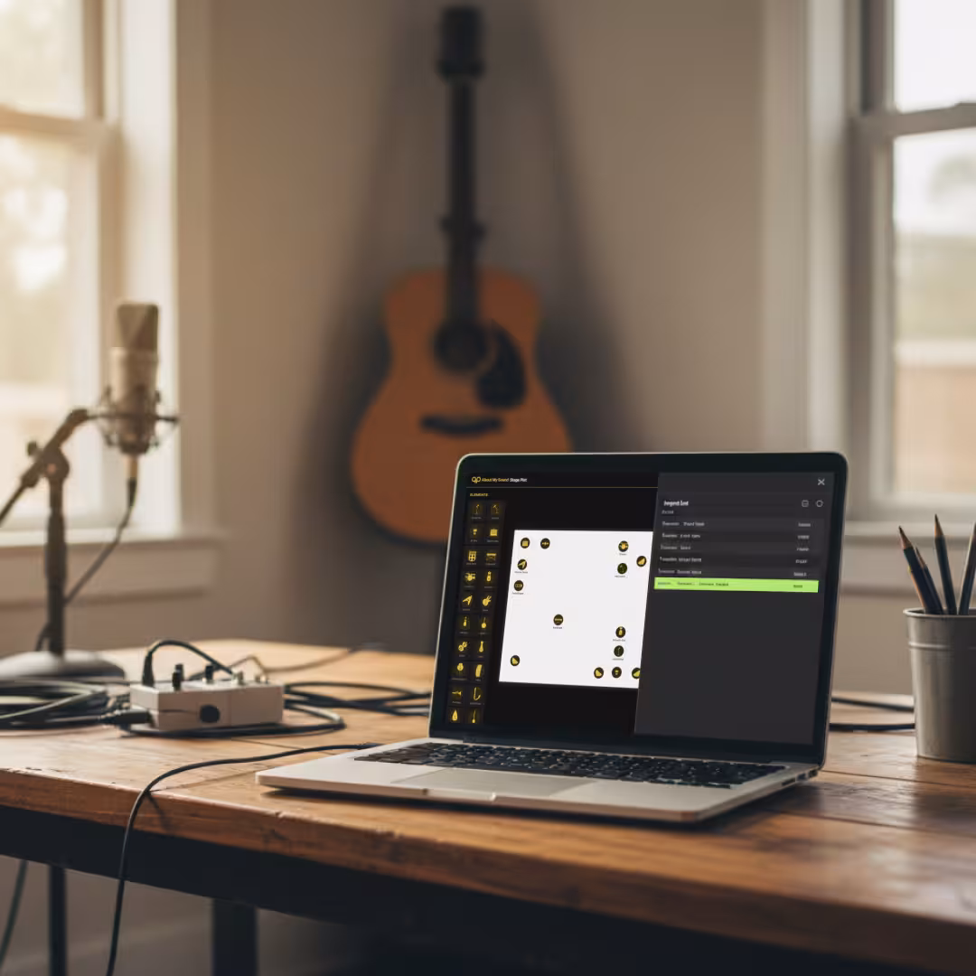 A desk with a guitar pedal, microphone, and a laptop open to the About My Sound Stageplot Generator.