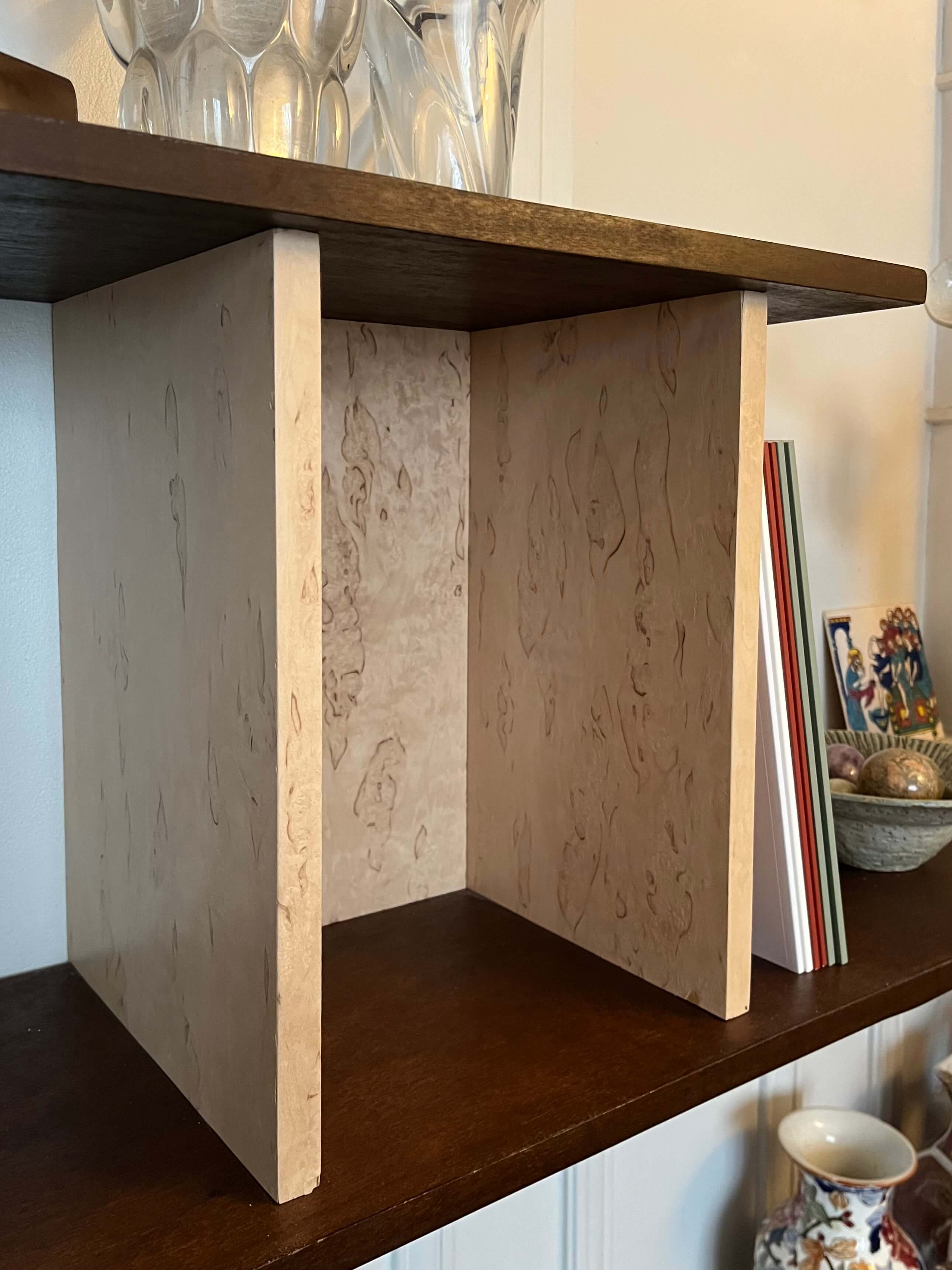 Etagères sur-mesure en okoumé teinté et huilé, aluminium et bouleau madré vernis. Meuble bas en okoumé teinté et huilé. Poignées la quincaillerie.