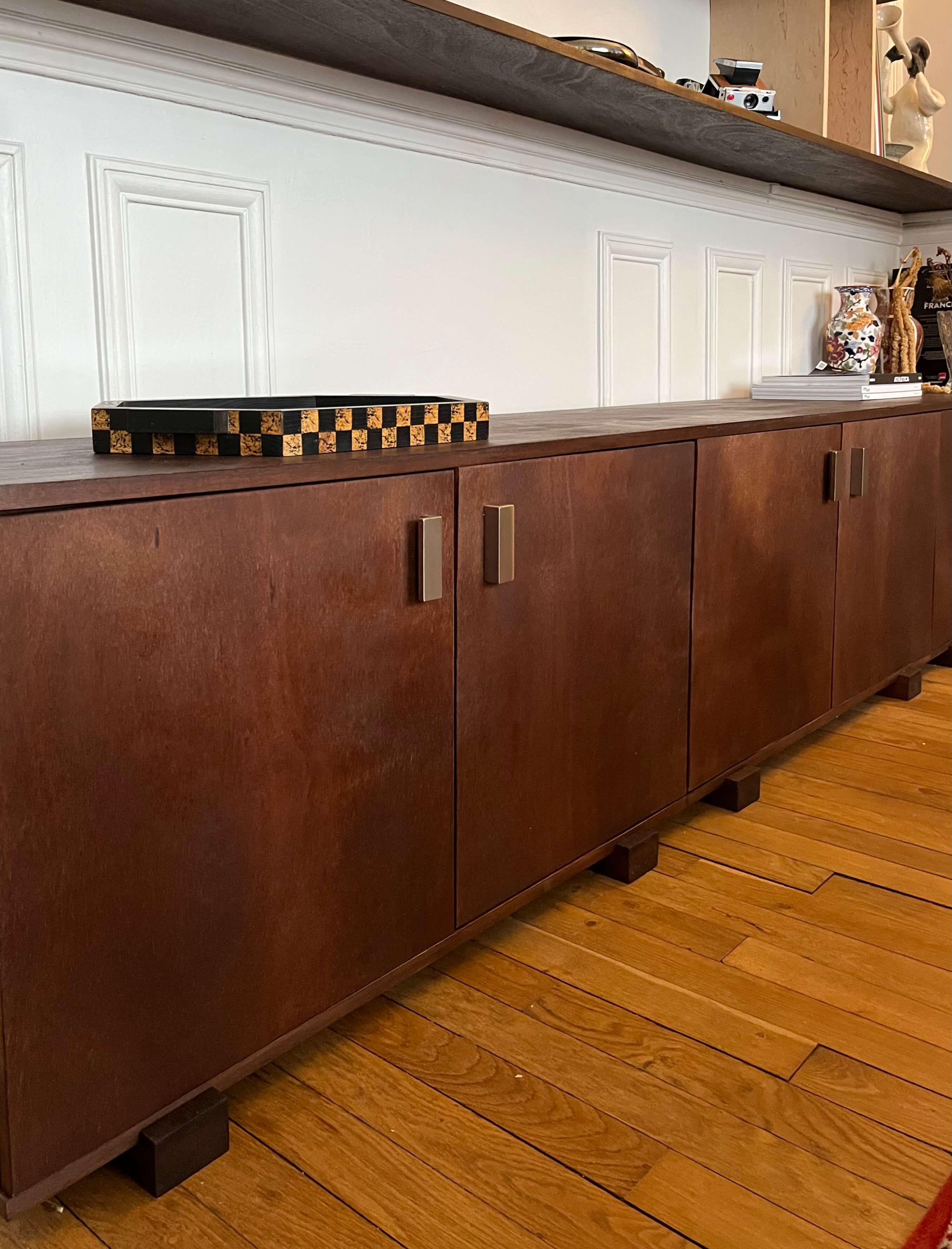 Etagères sur-mesure en okoumé teinté et huilé, aluminium et bouleau madré vernis. Meuble bas en okoumé teinté et huilé. Poignées la quincaillerie.