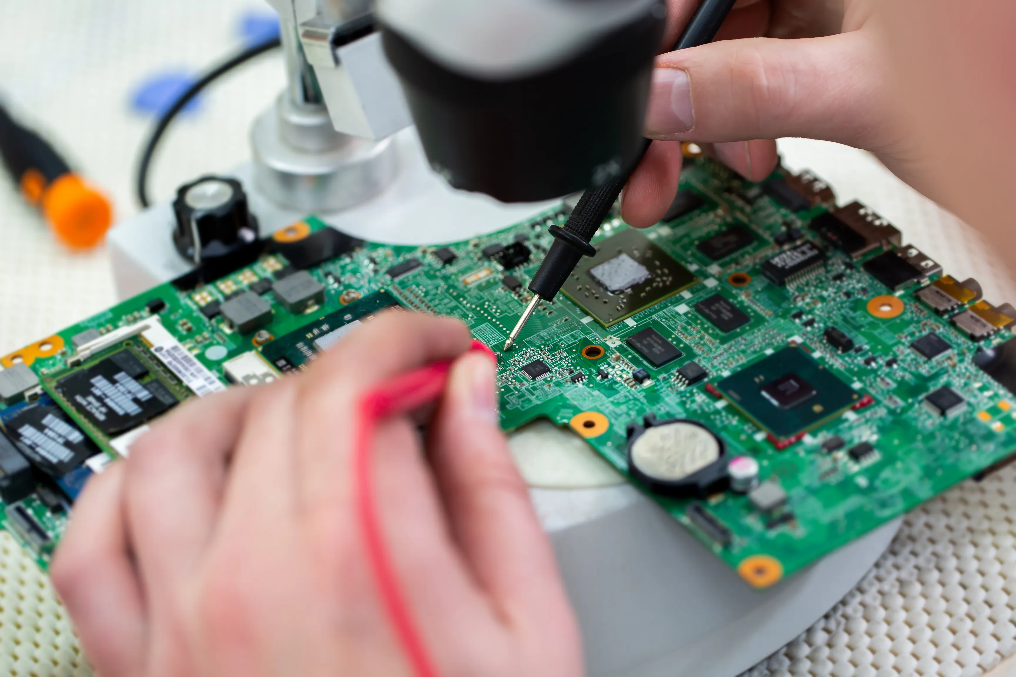 A technician using specialized tools to rework and reball a BGA (Ball Grid Array) on a PCB, carefully soldering and ensuring the connections are restored. This is part of the BGA rework and reballing process, which is crucial for repairing high-density circuit boards.