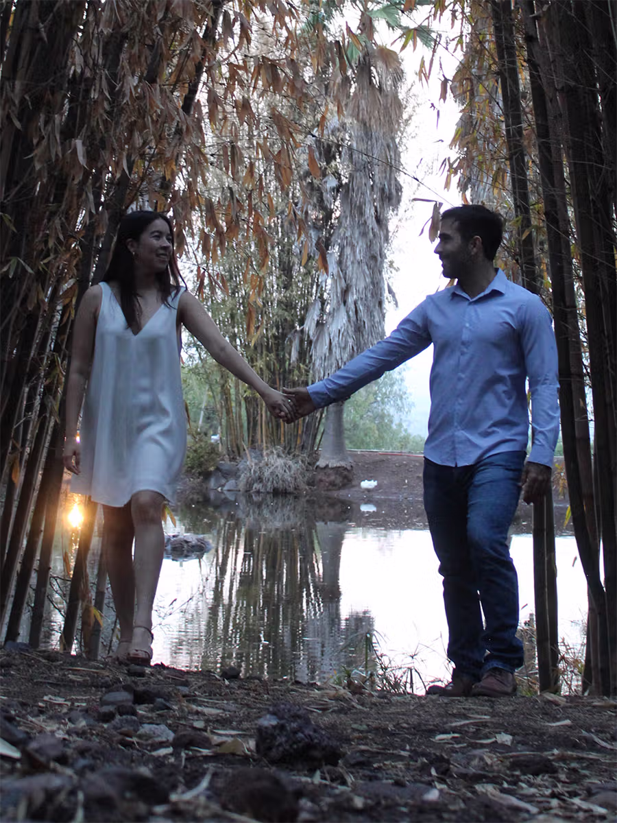 Arantxa y Eugenio tomados de la mano, a espaldas de un bordo de agua en Vista Real Querétaro.