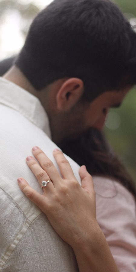 Arantxa y Eugenio abrazados en el parque Los Sabinos en Querétaro, la toma enfoca la mano de Arantxa con su anillo de compromiso.