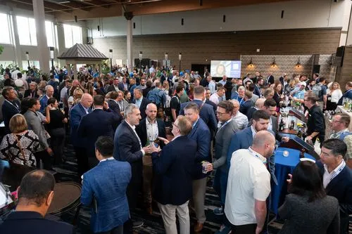 Hotel atrium filled with hundreds of conference attendees networking