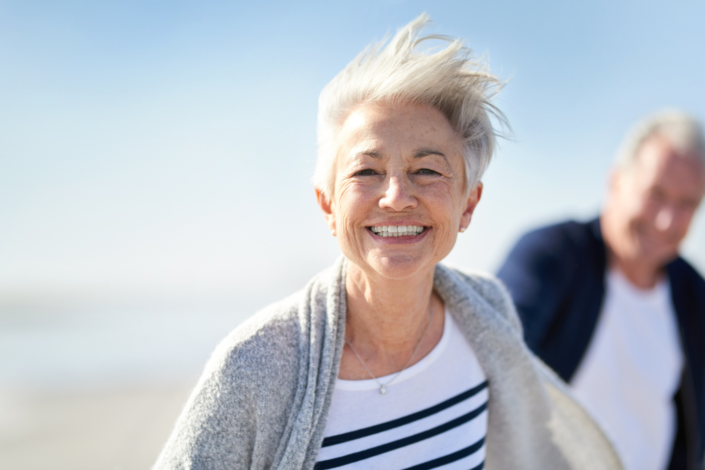 An older woman smiling on the beach