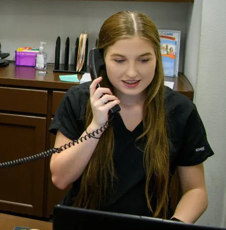Chiropractic office receptionist, answering a phone call from a patient.