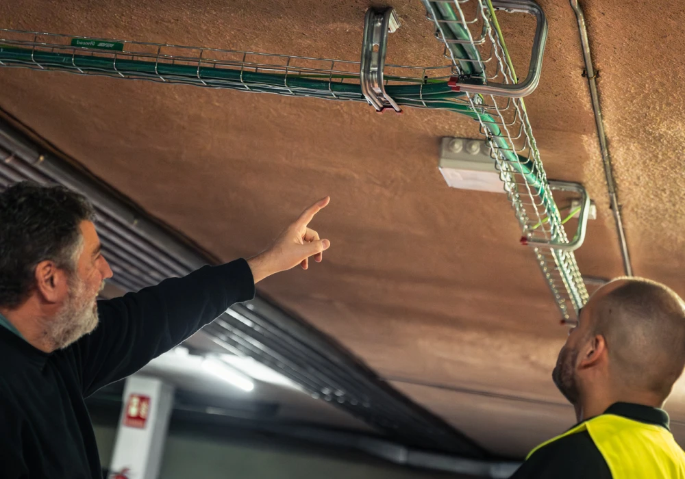 Dos Instaladores evaluando la zona para hacer una instalación de carga de coche eléctrico.