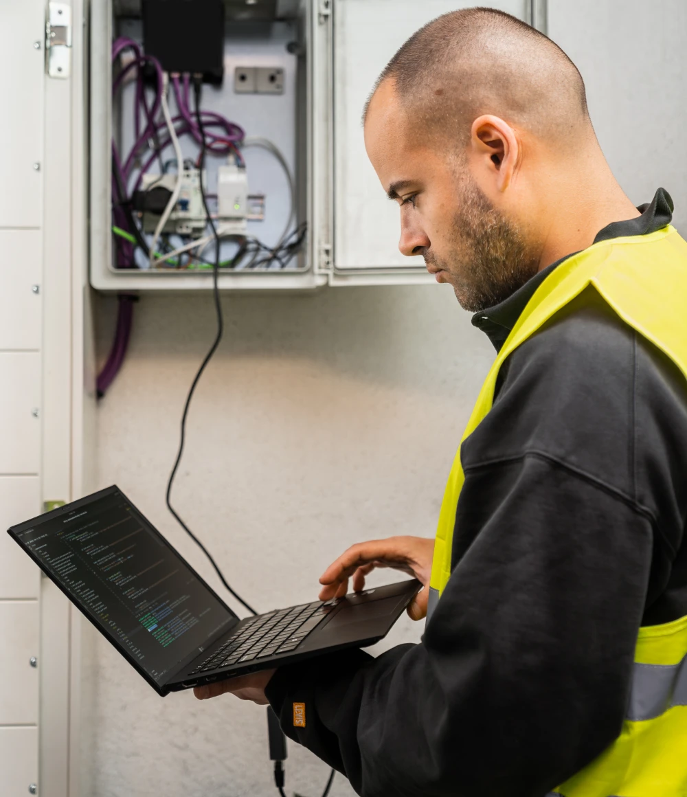 Instalador de Plavall con chaleco reflectante utiliza un ordenador portatil para configurar la instalación.