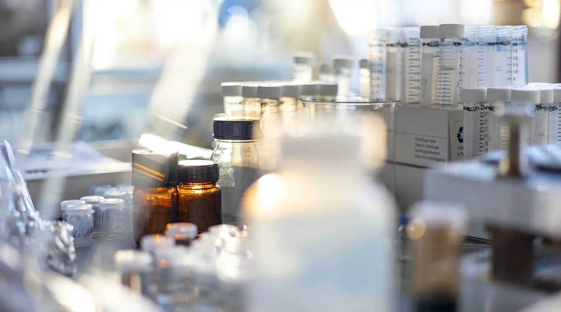 Clinical trial laboratory with amber glass bottles, centrifuge tubes, and sample vials