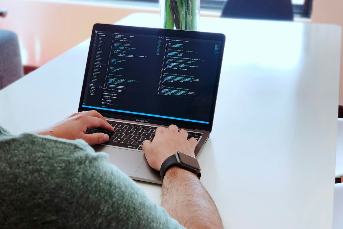 person using macbook pro on table