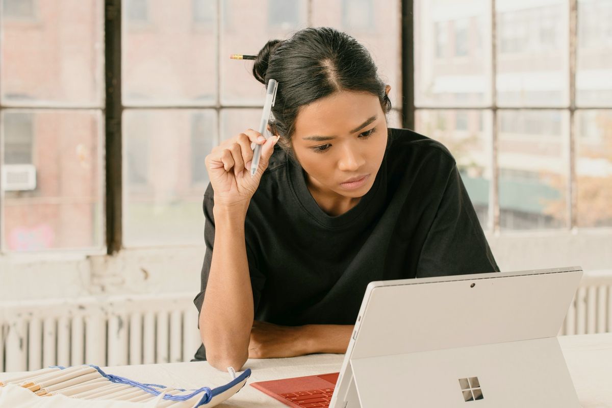 a woman sitting at a table using a laptop computer