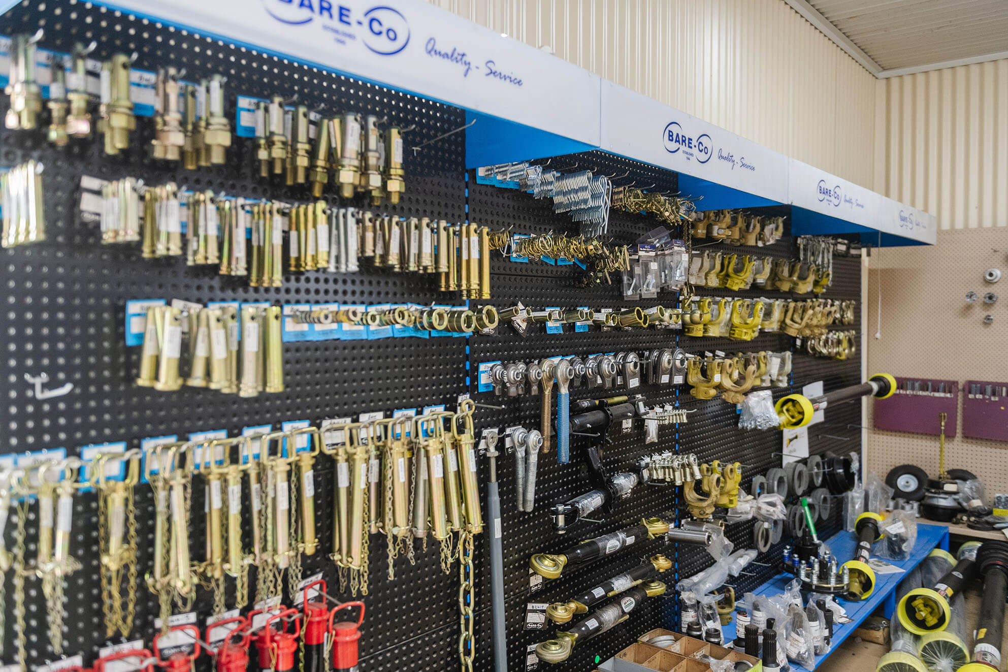 Wall display of hydraulic fittings and components in workshop store.